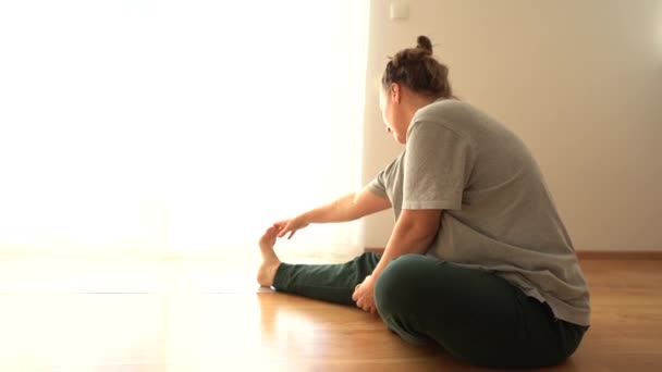 Hatha yoga fitness mother with baby. Mom and little son are doing stretching while sitting on the wooden floor of the house. Physical activity during the COVID-19 coronavirus lockdown — Stock Video