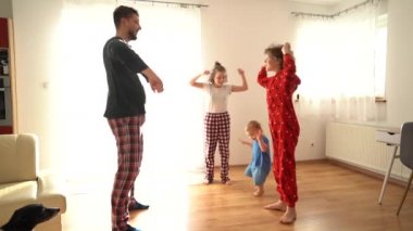 Sabahları pijamalarıyla egzersiz yapan üç çocuklu büyük bir aile. Eğlenceli kilitleme, evde kal, babalar günü