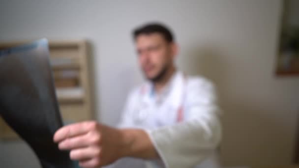 Doctors hand holds an x-ray picture of the patient. Close portrait. Doctor surgeon or pulmonologist at work in his office — Stock Video