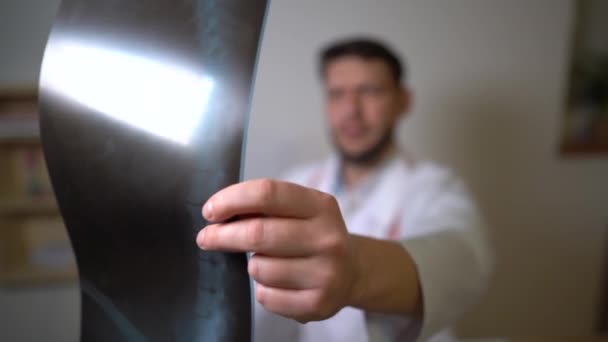 Doctor surgeon or pulmonologist at work in his office. Doctors hand holds an x-ray picture of the patient. Close portrait — Stock Video