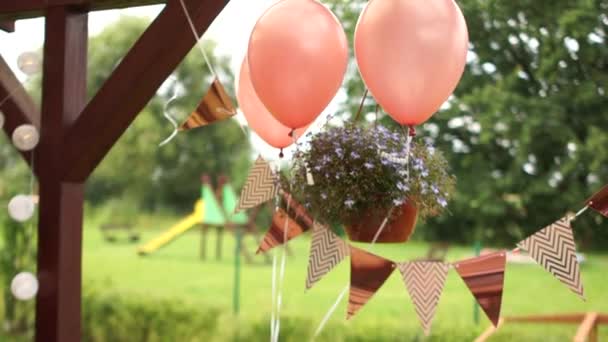 Празднование открытого праздника в саду. Воздушные шары и флаги коричневого цвета. Детский день рождения, концепция питания — стоковое видео