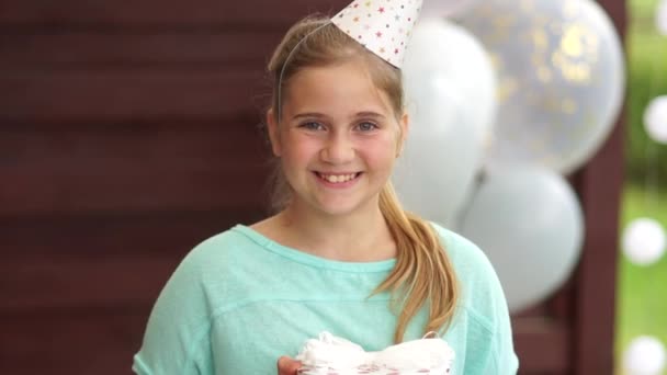 Tillykke med fødselsdagen pige holder en gaveæske i hendes hænder. Børns fødselsdag koncept, teenage pige smiler ind i kameraet, close-up portræt – Stock-video