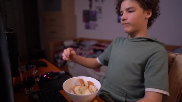 Concepto de videojuegos. Adolescente jugando con auriculares, sentado en la silla de su habitación en medio de un lío. Apuestas síntomas de adicción — Vídeo de stock