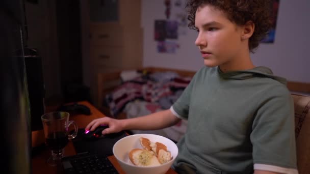 Teenage boy playing game sitting on chair in his room in the middle of a mess. Příznaky hráčské závislosti — Stock video