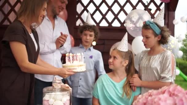 Pastel de cumpleaños y familia feliz. Adolescente celebrando su cumpleaños con la familia soplando las velas en su pastel — Vídeo de stock