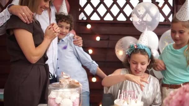 Una encantadora cumpleañera cuenta las velas del pastel con su familia y amigos. Familia feliz, cumpleaños de adolescentes — Vídeos de Stock