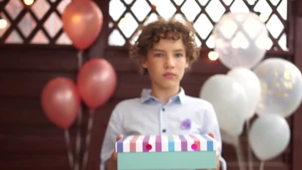 Urodzinowy chłopiec trzyma pudełka z prezentami w rękach i śmieje się radośnie. Koncepcja urodzin dzieci — Wideo stockowe