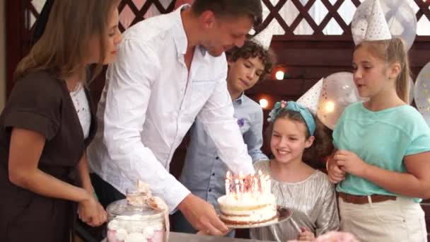 La famille félicite sa fille, fête d'anniversaire des enfants en plein air, concept de restauration. Joyeux anniversaire fille adolescente compter les bougies sur son gâteau d'anniversaire — Video