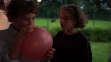 Bir erkek ve bir kız helyum dolu bir balon tutuyorlar. Havayı içine çek ve ince bir sesle konuş. Komik video, iyi eğlenceler.