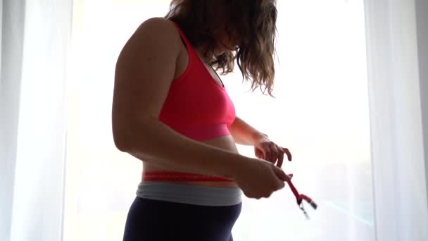 Femme en surpoids frustré mesurant la taille. Lance du ruban à mesurer dans le désespoir, dépression due à un excès de poids, récupération post-partum — Video