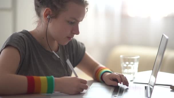 Giovane studentessa ha una lezione online a distanza. Ragazza che parla utilizzando cuffie e laptop, concetto di videochiamata — Video Stock
