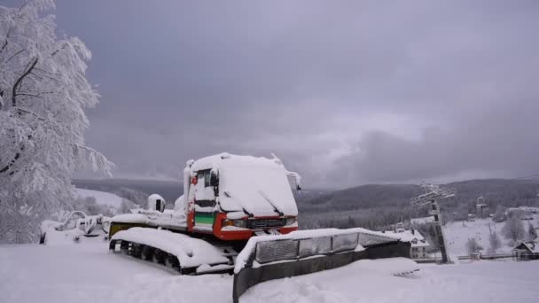 Poland, Zieleniec, Duszniki-Zdroj - 2021年1月10日.カルパチア山脈。スキー場のための雪の除去装置。雪に覆われたトラクターは、 covid-19ロックダウン中に立っています — ストック動画
