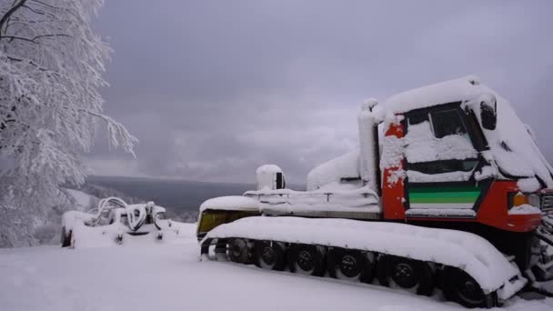 Utrustning för borttagning av snö till en skidort. En snötäckt traktor står under en covid-19 låsning. Karpaterna — Stockvideo