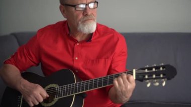 Gitar çalmayı öğrenen bir emeklinin portresi. Mutlu yaşlılıklar, favori hobi