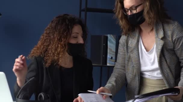 女秘书带来签字文件供公司所有人签署。办公室里的女人都戴着防护面具。新的常态。封锁期间的工作概念 — 图库视频影像
