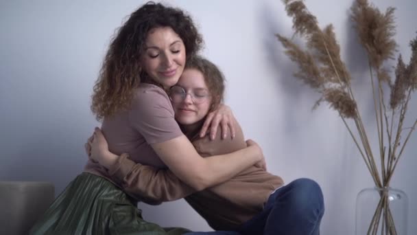 Μητέρα και έφηβη κόρη αγκαλιάζονται από κοντά. Μαμά και κόρη αγκαλιάζονται στο σπίτι. Ημέρα μητέρων — Αρχείο Βίντεο