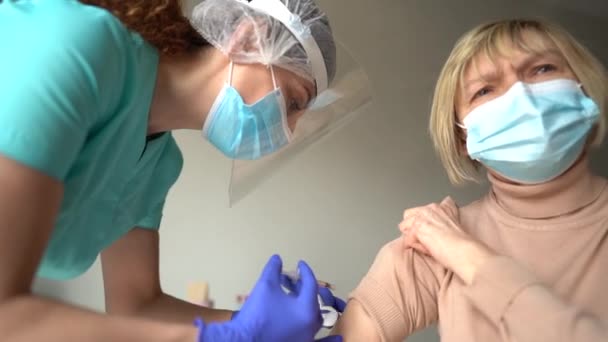 Trabajador médico vacunando a un paciente anciano contra la gripe, influenza, neumonía o coronavirus covid-19. Mujer mayor recibiendo la vacuna. Inmunización segura para ancianos concepto — Vídeos de Stock