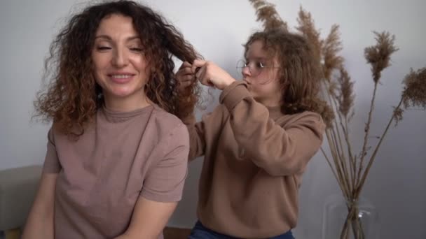 Daughter braids moms braids. Indoor portrait of happy mother and daughter spend weekend together. Mothers Day — Video