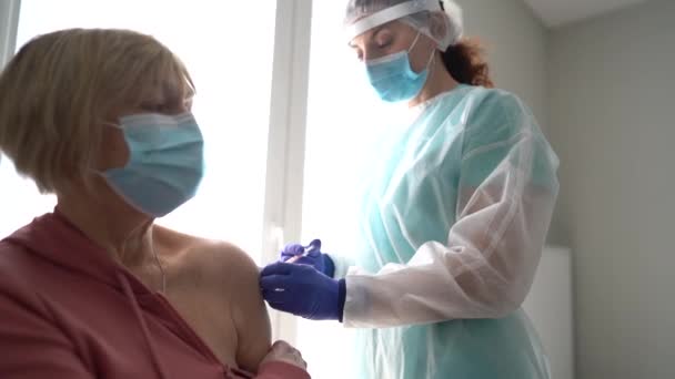 Médico vacunando a una mujer mayor. Protección contra virus. COVID-2019. Mujer mayor que recibe la vacuna contra el coronavirus — Vídeos de Stock