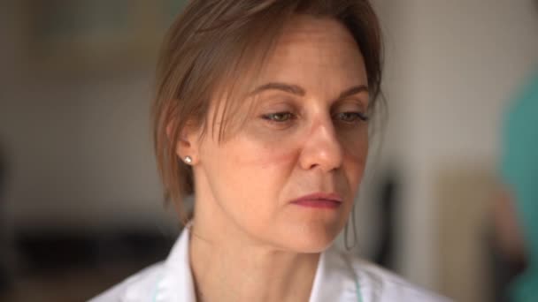 Retrato de uma médica cansada e triste com vestígios de uma máscara no rosto. O trabalho dos médicos durante a epidemia coronavírus covid-19 — Vídeo de Stock