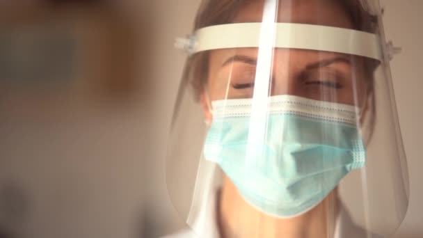 Vaccination against coronavirus covid-19. Portrait of a girl in a protective mask and shield with a dose of vaccine in her hand — Stock Video