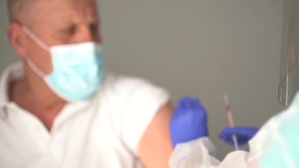 Infirmière de soins à domicile injectant à un homme âgé. Vidéo blued, mise au point sur la seringue d'insuline avec vaccin — Video
