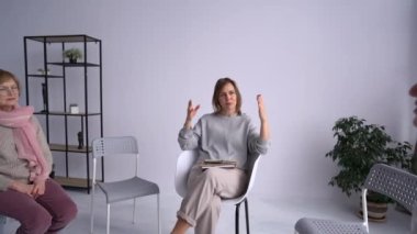 Kadın psikoterapist bir psikoterapi toplantısına liderlik ediyor. Psikolog konuşur ve etraftaki kadınlar dikkatlice dinler.