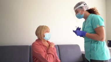 Yaşlı bir hastayı grip, grip, zatürree ya da koronavirüs kovid 19 'a karşı aşılayan bir tıp çalışanı. Yaşlı kadın aşı yaptırıyor. Yaşlılar için güvenli bağışıklık