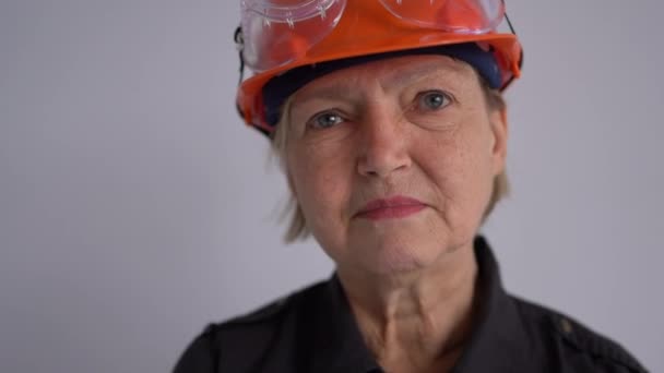 Portret van een volwassen vrouw bouwer in een helm. Het beroep is civiel ingenieur of architect. Glimlachende professionele vrouw — Stockvideo
