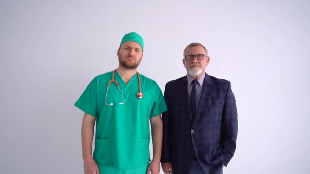 Young doctor with a phonendoscope and a mature lawyer in a business suit are standing nearby. Cooperation of different professions, health insurance concept — Stock Video