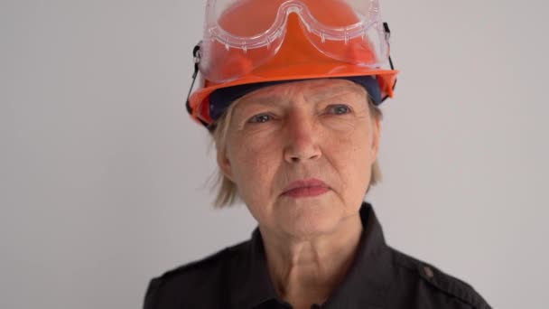 주황색의 딱딱 한 모자를 쓴 성숙 한 여성 건설 기술자가 메가폰으로 소리를 지릅니다. 중요 한 발표, 프로 활동 — 비디오