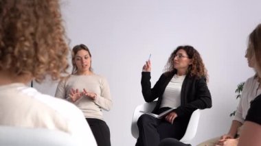 Psikoterapi seansı, grup çalışması, kadın çemberi, psikolojik takımyıldızları. Genç bir kadın grup terapisinde sorunlarından bahsediyor.