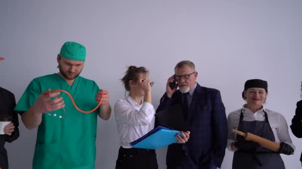 Il concetto del Labor Day. Varie professioni e professioni, costruttore, medico, segretario, avvocato, cuoco, consulente. Sei persone in uniforme di diverse professioni — Video Stock