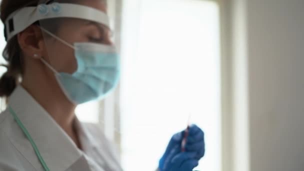 Ritratto di infermiera con una siringa in mano. Pandemia globale e vaccinazione contro il coronavirus covid-19 — Video Stock