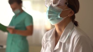 Yorgun doktor gözlüğünü ve maskesini çıkardı. Çalışma gününün sonunda, covid-19 salgını sırasında bir doktorun sıkı çalışmasına ara verin.