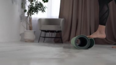 Meditasyon zamanı. Dersten önce kız evde yerde spor paspası sallıyor. Eller ve bacaklar kapalı, mindere odaklan.