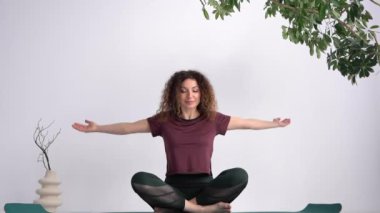 Namaste gesture. The yoga instructor completes the workout while sitting in the lotus position. Adult woman practicing meditation sitting on mat