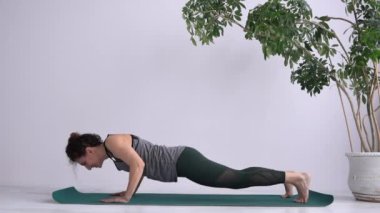 Cobra position. Attractive adult girl performs exercises while standing barefoot on a mat. Yoga Assana training. Exercises to stretch and strengthen your back muscles