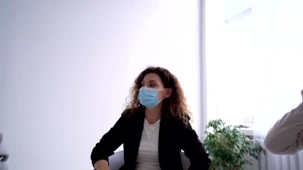 A female psychologist in a mask leads a psychological therapy meeting during a pandemic. Psychological assistance during and after the lockdown coronavirus covid-19 — Video