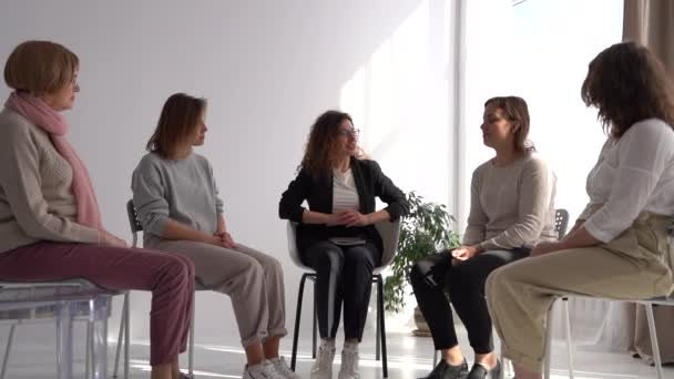 Giovane donna si presenta e parla di sé a un incontro di gruppo di donne terapeutiche guidato da una psicoterapeuta — Video Stock