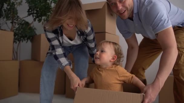 Opgewonden tijd voor een mooie familie vader en moeder spelen met de kleine jongen in het nieuwe huis, genieten van het moment op een nieuwe plaats — Stockvideo