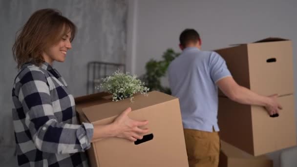 Gelukkig jong stel verhuist naar een nieuw appartement. Man en vrouw plannen het uitpakken van spullen. Verhuizing naar een nieuw huis, verandering van woonplaats, nieuw leven — Stockvideo