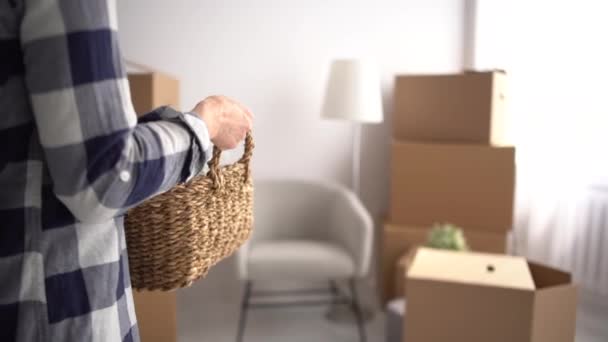 Young woman is busy moving to a new apartment. Brings in boxes and sits down to rest, smiles happily — Stock Video