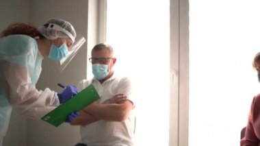 Hemşire, emeklilerin aşı öncesi kontrol listelerini bir hastanede ya da bakımevinde tamamlamalarına yardımcı olur. Risk grupları, aşının ilk aşaması. Nüfusun covid-19 Coronavirus 'a karşı bağışıklığı