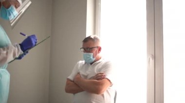 Bağışıklık sistemi. Doktor bir huzurevinde aşılanmadan önce anket ya da tıbbi kayıt doldurur. Aşı için hazırlık, ilk aşama.
