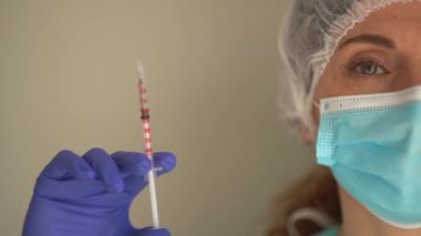 Tıbbi maske takan ve şırıngayı aşıyla dolduran Doktor veya Hemşire portresi. Aşılama Kavramı
