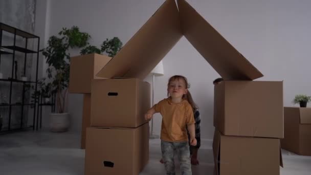 Père, mère et enfant s'amusent ensemble. Journée déménagement et concept immobilier. Portrait d'une jeune famille avec un tout-petit déménageant dans une nouvelle maison — Video