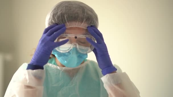 Una dottoressa durante una pausa. L'infermiera toglie la maschera e gli occhiali e inala l'aria. Dottore esausto — Video Stock