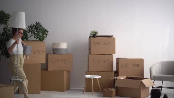 Mãe e filha desfrutar do novo apartamento, transportar caixas de coisas durante a realocação. Comprar uma nova casa, minimalismo e conceito decluttering — Vídeo de Stock