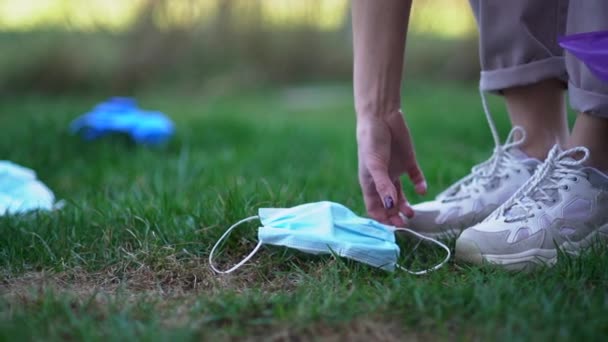 无法辨认的女性志愿者在公园里收集垃圾- -她们用的是面具和手套.环境污染和眼镜蛇-19型眼镜蛇流行病 — 图库视频影像